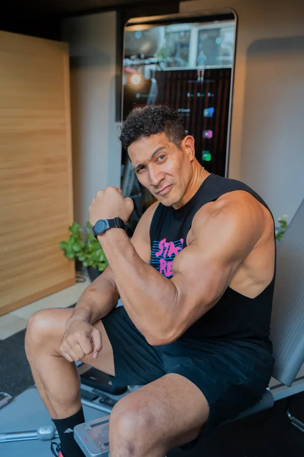 Eric Tai flexes his arm while seated in front of a lit ZYLO K1 screen.