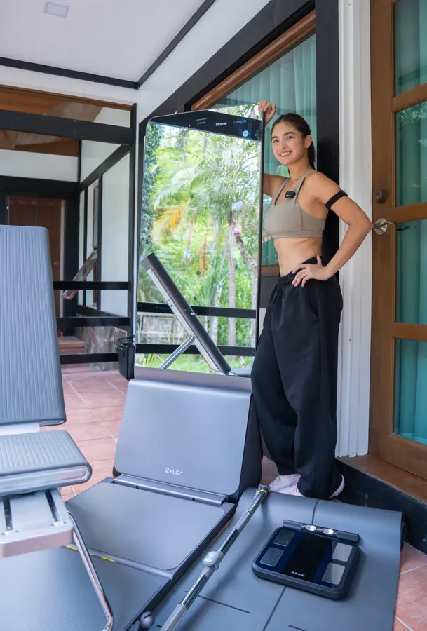 Heaven Peralejo smiles beside a ZYLO K1, resting her hand on top of its screen.