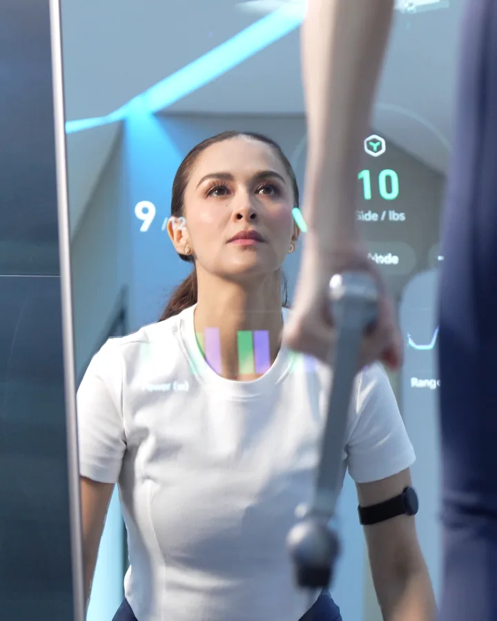 Marian Rivera, reflected in a lit ZYLO K1 mirror showing live workout stats, holds a cable handle.